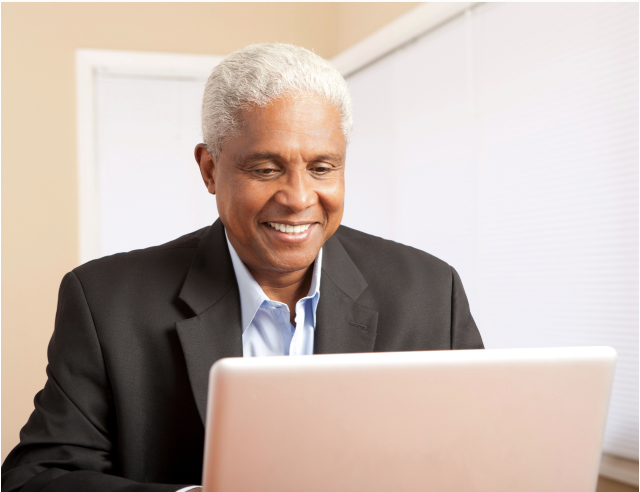 Elder African-American man smiling at computer screen